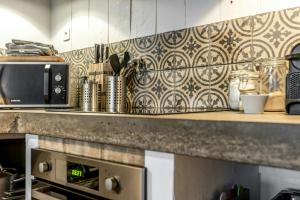 a kitchen with a counter top with a microwave at Citystyle Apartment In Medieval Monflanquin in Monflanquin