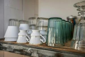 a shelf with cups and glasses on a counter at Citystyle Apartment In Medieval Monflanquin in Monflanquin