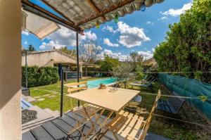 a patio with a table and chairs next to a pool at Chez Frédérique et Jean-Claude in Les Taillades