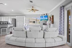 a living room with a white couch and a kitchen at Paradise PalmsDockPoolKayaks GrillView! in Marathon