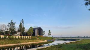 a small building on a hill next to a river at Maison Du Lac The Panoramic Glass Lodge in Wang Nam Khieo