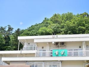 a building with a blue sign on the side of it at KKR Kinosaki Genbu in Kinosaki