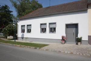 Casa blanca con 2 ventanas y una puerta en Zur Weinlaube, en Mönchhof