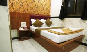a bedroom with a bed with a wooden headboard at FabHotel Star Hill in Mumbai
