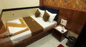 a hotel room with a bed and a side table at FabHotel Star Hill in Mumbai