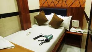 a bed with a pair of glasses on it at FabHotel Star Hill in Mumbai