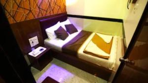 a small room with a bed and a night stand at FabHotel Star Hill in Mumbai