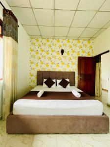 a bedroom with a large bed with yellow flowers on the wall at Villa Avora Ridge in Kandy +4 photos