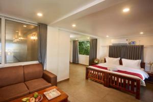 a hotel room with a bed and a couch at Akanta Cherai Beach Resort in Cochin