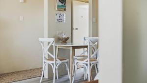 a dining room with a table and four chairs at Priority Beach Stay in Coffs Harbour +7 photos