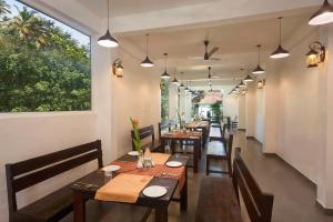 a dining room with tables and chairs and a window at Akanta Cherai Beach Resort in Cochin