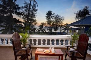 a patio with two chairs and a table and a balcony at Akanta Cherai Beach Resort in Cochin