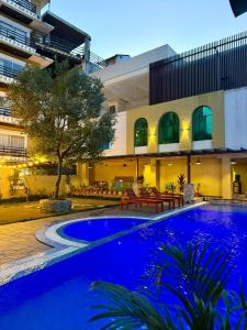 a large swimming pool in front of a building at Bodhi Suite Boutique Hotel & Wellness in Pokhara