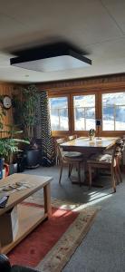 a room with a table and benches and windows at Ferienwohnung Toggilodge in Unterwasser