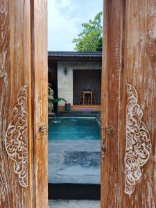 an open door to a backyard with a pool at Simbar Pertiwi Villa in Ubud