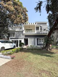 a white car parked in front of a house at Ardor Homestay in Jabalpur