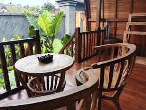 a wooden table and two chairs on a porch at Simbar Pertiwi Villa in Ubud