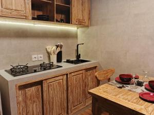a kitchen with a stove and a table with red dishes at Simbar Pertiwi Villa in Ubud