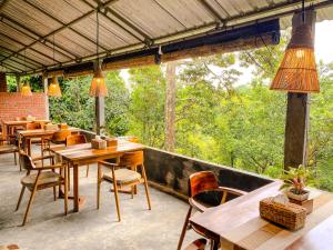 a restaurant with wooden tables and chairs on a patio at Wimala Farm House in Munduk