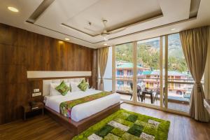 a bedroom with a bed and a large window at Tripli Hotels Shivaay in Dharamshala +142 photos