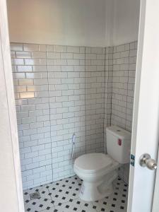 a bathroom with a toilet in a white tiled wall at Earnhomestay sichon in Ban Plai Thon +24 photos