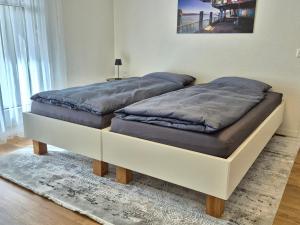 two beds sitting next to each other in a room at Stilvolles Wohnen an der Goldküste, nahe Zürich - 55m2 in Erlenbach +11 photos