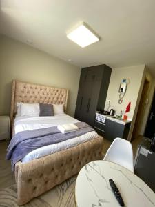 a bedroom with a large bed and a table at Staunch Homes Luxury Studio Apartment in Nairobi