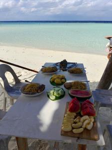a picnic table on the beach with food on it at Karanka Villa @ Mahibadhoo in Mahibadhoo
