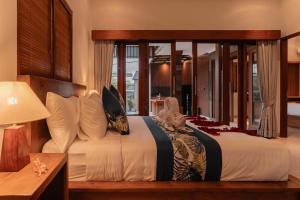 a bedroom with a large bed with a large window at Villa Mesari Bona in Blahbatu