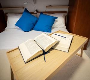 two books on a wooden table next to a bed at Dimora del Mare in Isola Bacucco