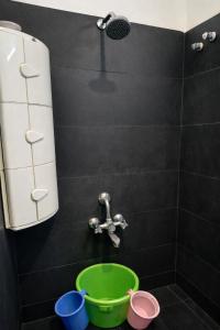 a bathroom with a faucet and a green bucket at Mutram Heritage Stay in Kanchipuram +135 photos