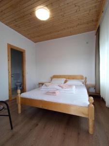 a bed in a room with a wooden ceiling at Casa Didi in Vama Veche