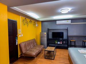 a living room with a couch and a television at Nangnon Hill Hug Hotel in Ban Pa Muat