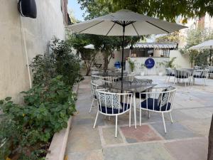 a table and chairs with an umbrella on a patio at Ramat Niwas By Kutani Stays in Jaipur