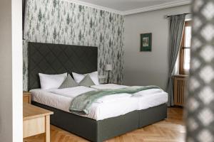 a bedroom with a bed with a green blanket on it at Hotel Bachmair Alpina in Rottach-Egern +73 photos