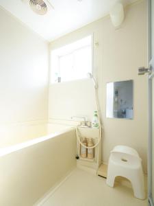 a bathroom with a tub and a toilet and a window at ROOMzero 5号室 in Hanazonomachi
