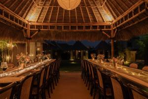 a long dining table in a restaurant with chairs at Wildflower Events in Uluwatu +89 photos