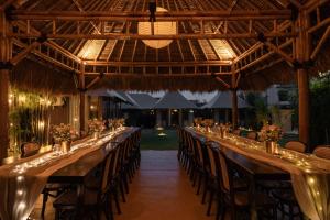 a long table in a pavilion with chairs and lights at Wildflower Events in Uluwatu