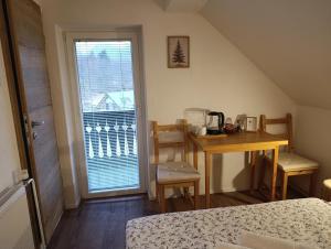 a room with a desk and a table and a window at Apartments and rooms Cerkovnik in Bohinj