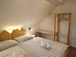a bedroom with a bed with two towels on it at Apartments and rooms Cerkovnik in Bohinj