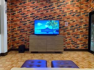 a flat screen tv sitting on a stand in front of a brick wall at Nangnon Hill Hug Hotel in Ban Pa Muat +14 photos