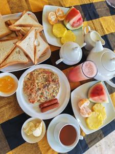 a table with plates of food and cups of tea at E-Beach Resort in Negombo