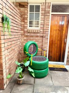 a green chair sitting in front of a house at Bonno Stay Suite in Gaborone