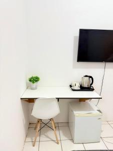 a white desk with a tv and a chair at Bonno Stay Suite in Gaborone