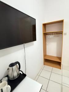 a tea kettle sitting on a table in front of a flat screen tv at Bonno Stay Suite in Gaborone