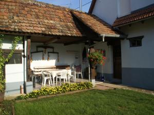 a patio with a table and chairs under a roof at Holiday Home Alsace near Vosges Nature Park in Schleithal