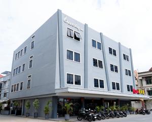 a large building with motorcycles parked in front of it at Hotel Beverly Inn Batam Center in Batam Center