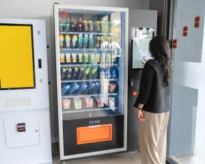 a woman is standing in front of a refrigerator at Hotel Beverly Inn Batam Center in Batam Center
