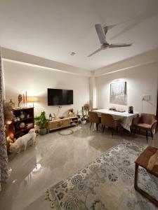 a living room with a table and a ceiling fan at Aga Stay Apartment in Gangtok