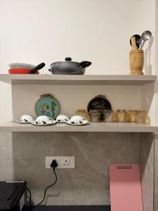 a shelf with bowls and other items on it at Aga Stay Apartment in Gangtok